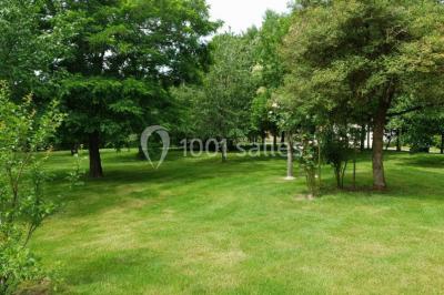 Tables décorées pour un événement avec chandeliers, compositions florales suspendues et lumière tamisée.