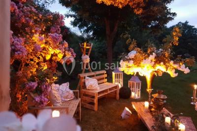 Tables décorées pour un événement avec chandeliers, compositions florales suspendues et lumière tamisée.