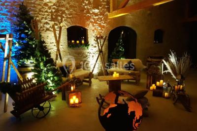 Tables décorées pour un événement avec chandeliers, compositions florales suspendues et lumière tamisée.