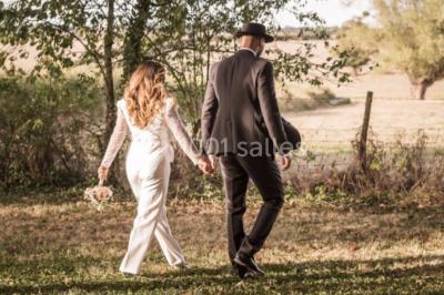 Tables décorées pour un événement avec chandeliers, compositions florales suspendues et lumière tamisée.
