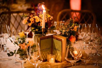 Tables décorées pour un événement avec chandeliers, compositions florales suspendues et lumière tamisée.