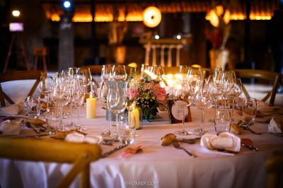 Tables décorées pour un événement avec chandeliers, compositions florales suspendues et lumière tamisée.