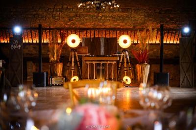 Tables décorées pour un événement avec chandeliers, compositions florales suspendues et lumière tamisée.