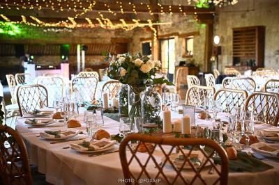 Tables décorées pour un événement avec chandeliers, compositions florales suspendues et lumière tamisée.
