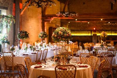 Tables décorées pour un événement avec chandeliers, compositions florales suspendues et lumière tamisée.