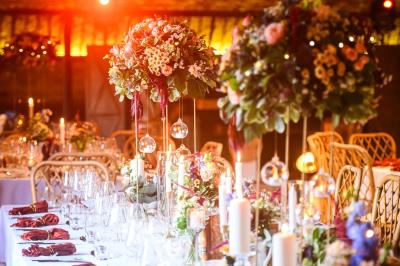 Tables décorées pour un événement avec chandeliers, compositions florales suspendues et lumière tamisée.
