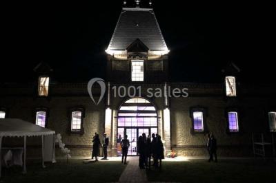 Chambre lumineuse avec lit double, draps bleus, moustiquaire suspendue et éclairage doux.