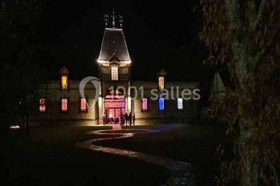 Chambre lumineuse avec lit double, draps bleus, moustiquaire suspendue et éclairage doux.