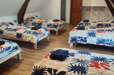 Salle de réception décorée avec des tables rondes, nappes blanches, chaises blanches et centres de table fleuris.