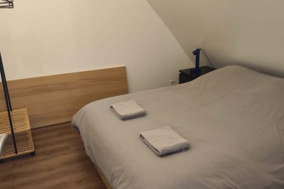 Salle de réception décorée avec des tables rondes, nappes blanches, chaises blanches et centres de table fleuris.