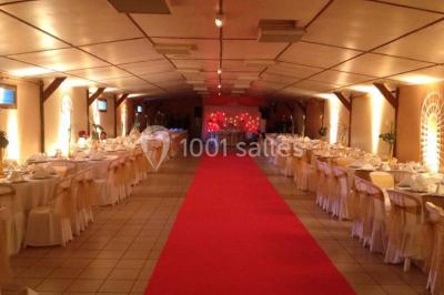 Table de candy bar décorée avec des bonbons variés, lanternes suspendues et éclairage violet en arrière-plan.