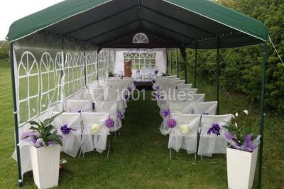Table de candy bar décorée avec des bonbons variés, lanternes suspendues et éclairage violet en arrière-plan.