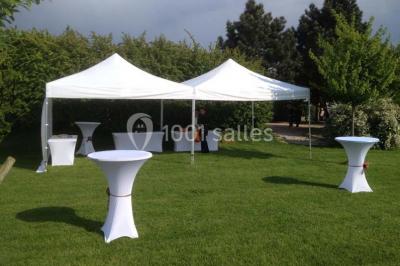 Table de candy bar décorée avec des bonbons variés, lanternes suspendues et éclairage violet en arrière-plan.