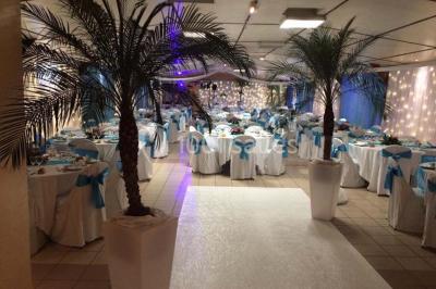 Table de candy bar décorée avec des bonbons variés, lanternes suspendues et éclairage violet en arrière-plan.