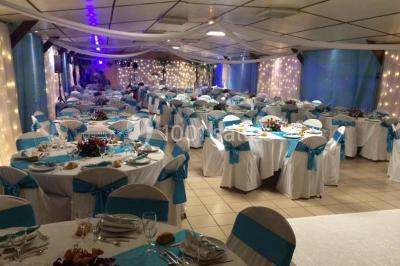 Table de candy bar décorée avec des bonbons variés, lanternes suspendues et éclairage violet en arrière-plan.