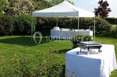 Table de candy bar décorée avec des bonbons variés, lanternes suspendues et éclairage violet en arrière-plan.