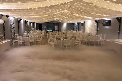 Table de candy bar décorée avec des bonbons variés, lanternes suspendues et éclairage violet en arrière-plan.