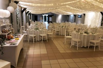 Table de candy bar décorée avec des bonbons variés, lanternes suspendues et éclairage violet en arrière-plan.