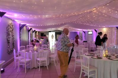 Table de candy bar décorée avec des bonbons variés, lanternes suspendues et éclairage violet en arrière-plan.