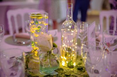 Table de candy bar décorée avec des bonbons variés, lanternes suspendues et éclairage violet en arrière-plan.
