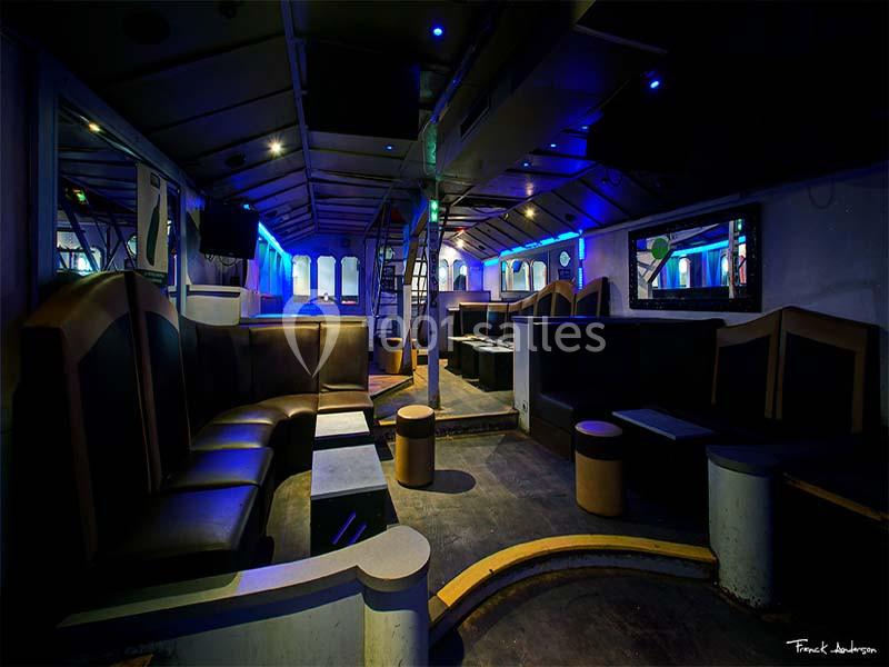 Intérieur d'une salle de réception moderne et vide, éclairée par des lumières bleues et violettes.