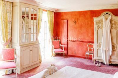 Vue d'une terrasse avec parasols et piscine, encadrée par des haies sombres et un ciel dégagé en arrière-plan.
