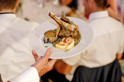 Vue d'une terrasse avec parasols et piscine, encadrée par des haies sombres et un ciel dégagé en arrière-plan.