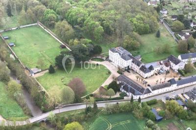 Écran de projection blanc déroulé dans une salle de conférence avec murs en bois et plafond équipé d'un projecteur.