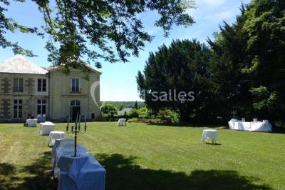 Écran de projection blanc déroulé dans une salle de conférence avec murs en bois et plafond équipé d'un projecteur.