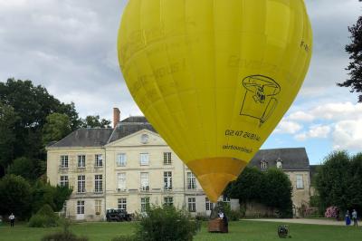 Écran de projection blanc déroulé dans une salle de conférence avec murs en bois et plafond équipé d'un projecteur.