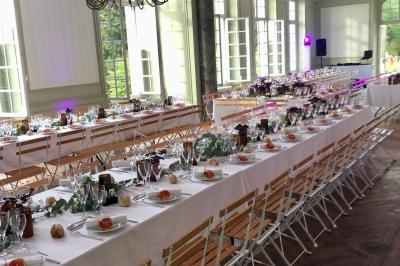 Écran de projection blanc déroulé dans une salle de conférence avec murs en bois et plafond équipé d'un projecteur.