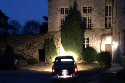Écran de projection blanc déroulé dans une salle de conférence avec murs en bois et plafond équipé d'un projecteur.