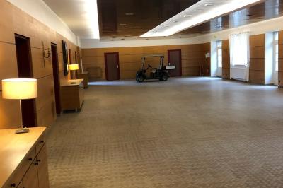 Écran de projection blanc déroulé dans une salle de conférence avec murs en bois et plafond équipé d'un projecteur.