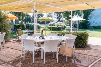 Chambre d'hôtel lumineuse avec lit double, canapé-lit, table basse, fenêtre et décoration moderne.