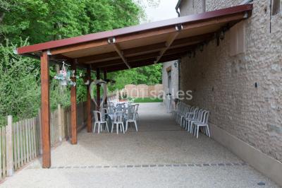 Stand en bois avec des boissons, verres et décorations tropicales, sous une pancarte ’Bar à cocktail’.