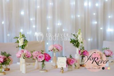 Stand en bois avec des boissons, verres et décorations tropicales, sous une pancarte ’Bar à cocktail’.