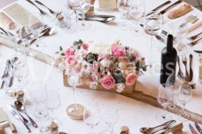Stand en bois avec des boissons, verres et décorations tropicales, sous une pancarte ’Bar à cocktail’.
