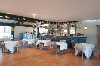 Terrasse en bois avec pergola, mobilier de jardin et façade vitrée donnant sur un espace intérieur moderne.