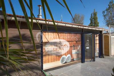 Terrasse en bois avec pergola, mobilier de jardin et façade vitrée donnant sur un espace intérieur moderne.