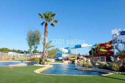 Terrasse en bois avec pergola, mobilier de jardin et façade vitrée donnant sur un espace intérieur moderne.