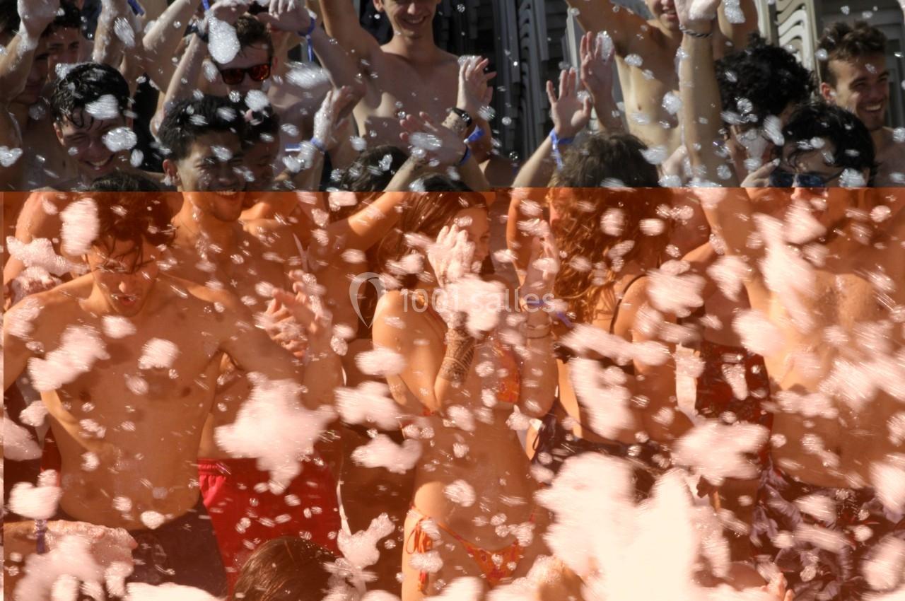 Des personnes en maillot de bain participent à une fête en plein air avec de la mousse.