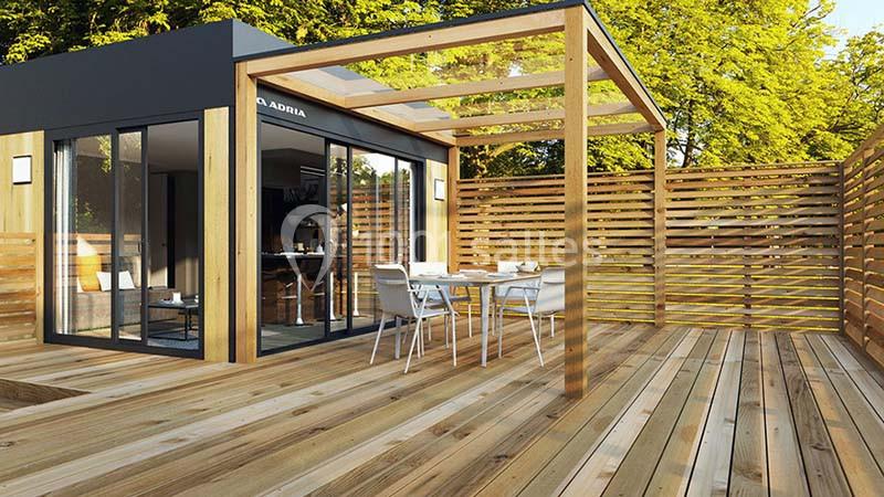 Terrasse en bois avec pergola, mobilier de jardin et façade vitrée donnant sur un espace intérieur moderne.