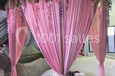 Cuillères transparentes disposées en cercle sur une assiette noire, remplies de semoule garnie de légumes et herbes.