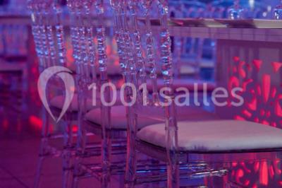 Cuillères transparentes disposées en cercle sur une assiette noire, remplies de semoule garnie de légumes et herbes.