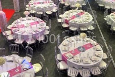 Cuillères transparentes disposées en cercle sur une assiette noire, remplies de semoule garnie de légumes et herbes.