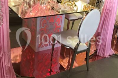 Cuillères transparentes disposées en cercle sur une assiette noire, remplies de semoule garnie de légumes et herbes.