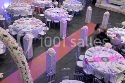 Cuillères transparentes disposées en cercle sur une assiette noire, remplies de semoule garnie de légumes et herbes.