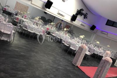 Cuillères transparentes disposées en cercle sur une assiette noire, remplies de semoule garnie de légumes et herbes.