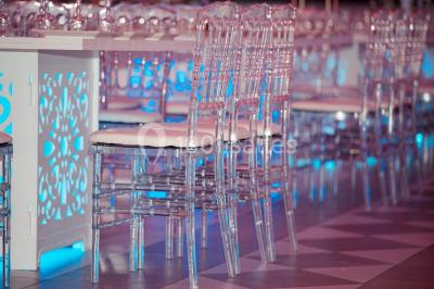 Cuillères transparentes disposées en cercle sur une assiette noire, remplies de semoule garnie de légumes et herbes.