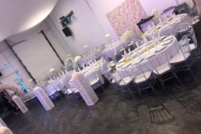 Cuillères transparentes disposées en cercle sur une assiette noire, remplies de semoule garnie de légumes et herbes.